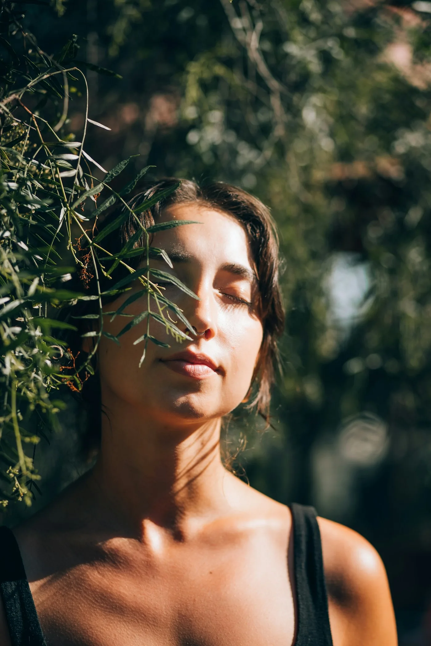 Una mujer hace una pausa tranquila al aire libre, bajo la luz del sol.